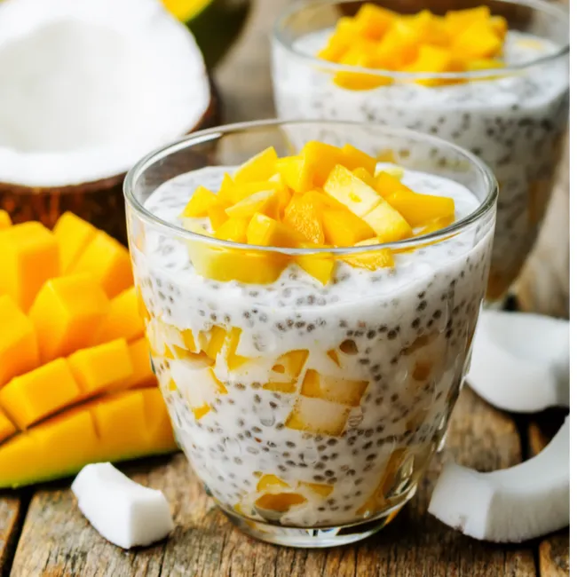 chia seeds mango pudding glass on brown wooden table