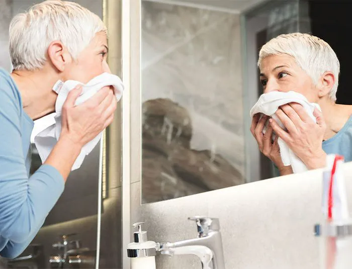 Middle aged woman cleansing her face