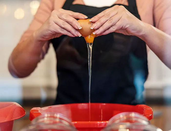 Woman cracking eggs into a bowl