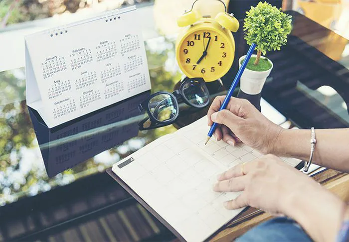 Person writing on calendar
