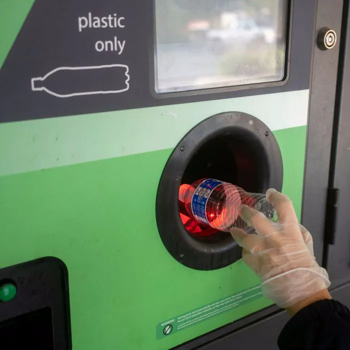 walmart bottle depositing machine woman dropping bottle in with gloves