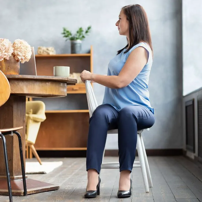 woman stretching spine in chair