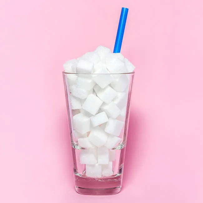 sugar cubes in a glass with a straw