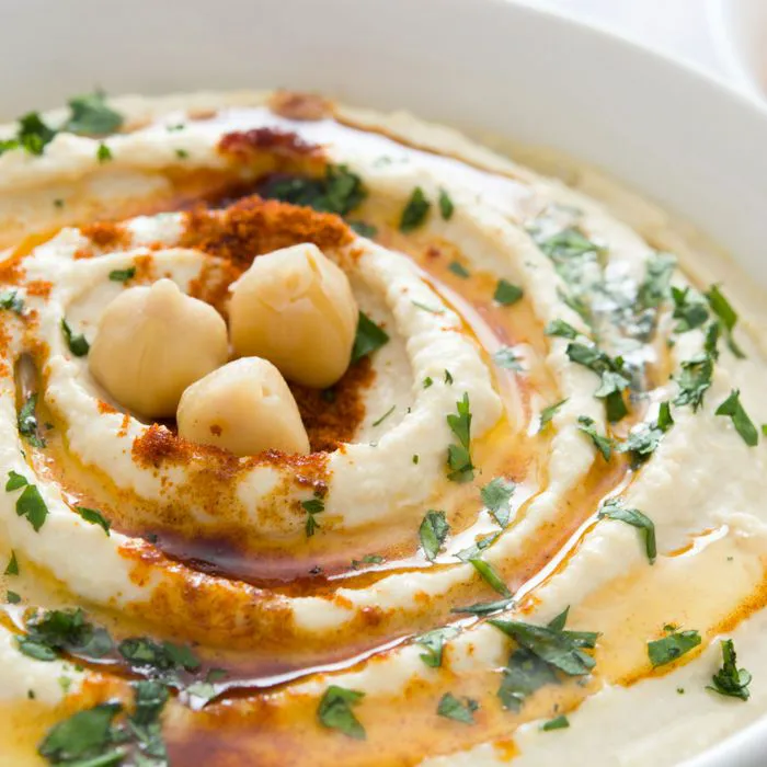 "Creamy hummus served with pita bread and assorted vegetables"