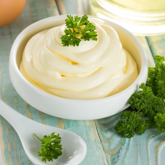 "Bowl of mayonnaise with a spoon"