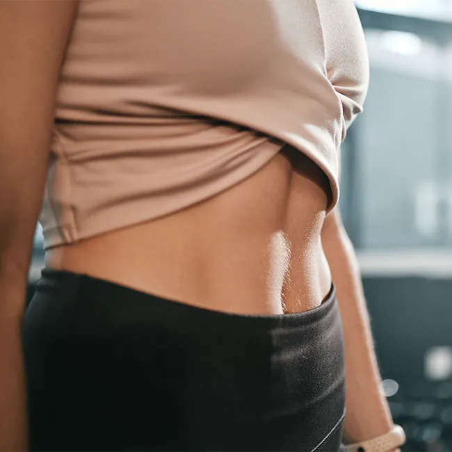 "Woman with flat abs exercising at the gym"