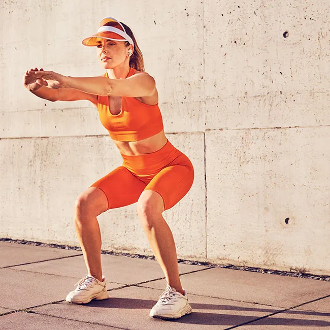 Woman doing squats to enhance lower body strength.