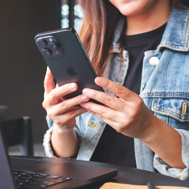 Woman using an iPhone 15 Pro Max smartphone