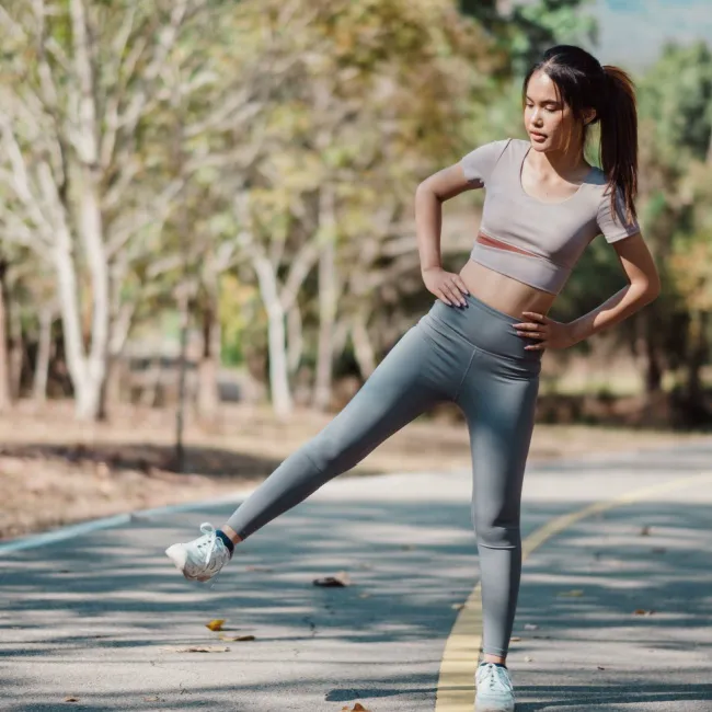 "Woman doing a curtsy step-up exercise"