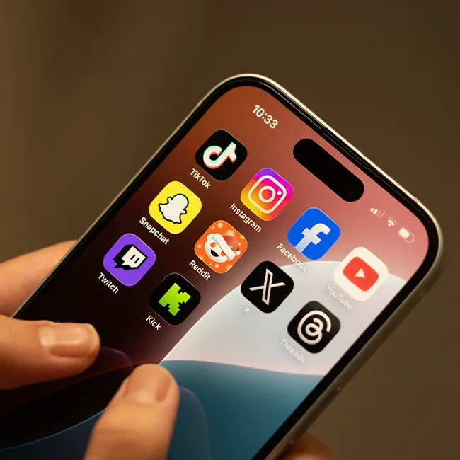 Person using iPhone with visible social media applications.