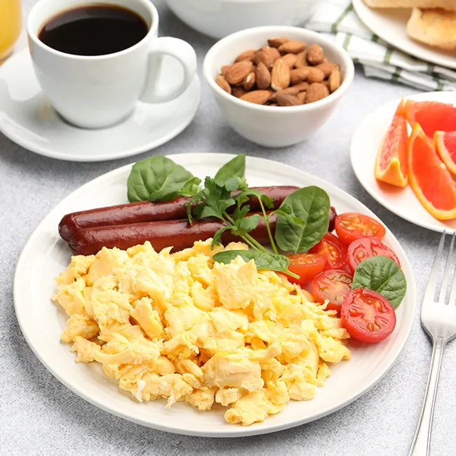 "Scrambled eggs breakfast with sausage and tomato"