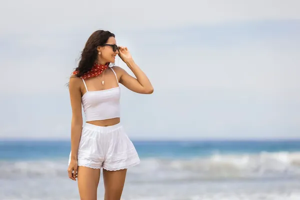 "Stock image of sunglasses and sunscreen on a beach"