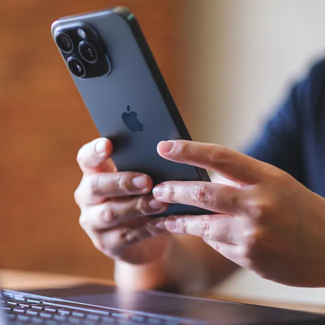 "Typing on an iPhone with fingers on the screen"