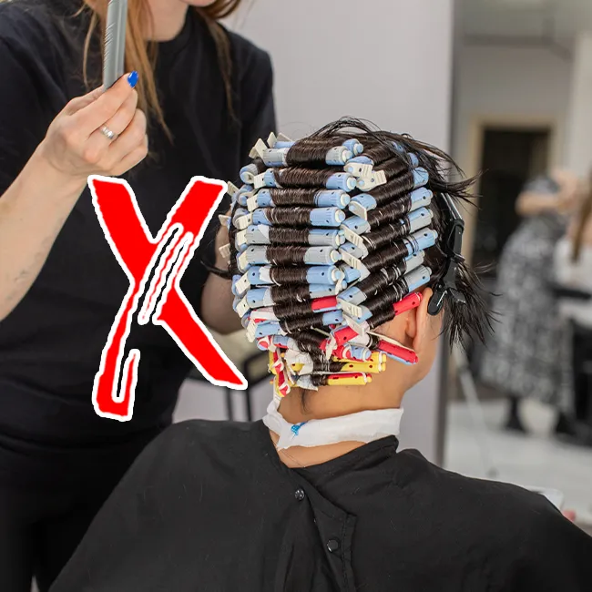 Woman getting a perm for voluminous curls.