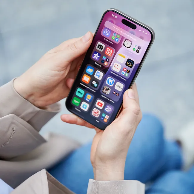 "Woman holding an iPhone in a modern setting"